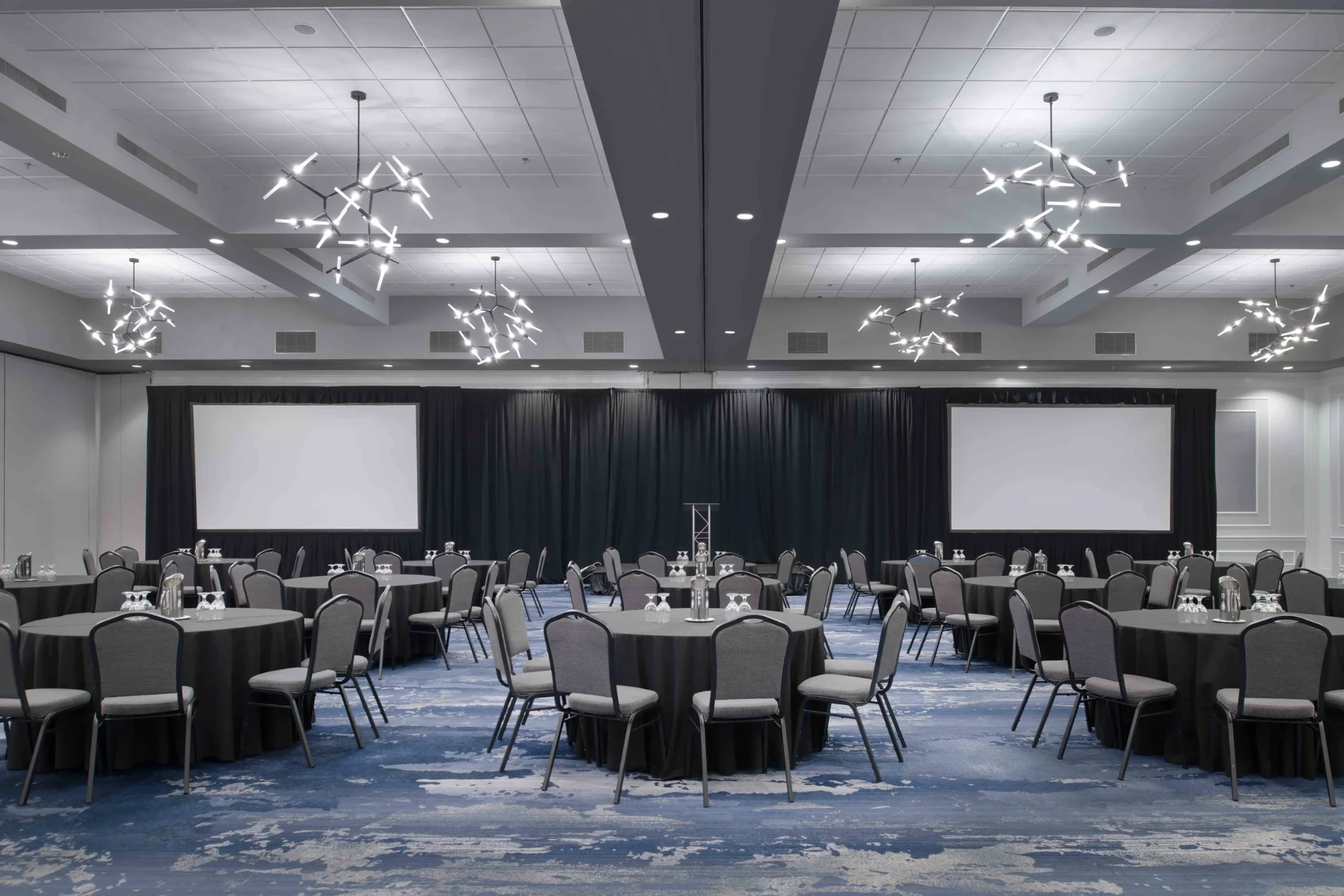 The Grand Ballroom at the Renaissance Framingham, set with round tables facing two presentation screens