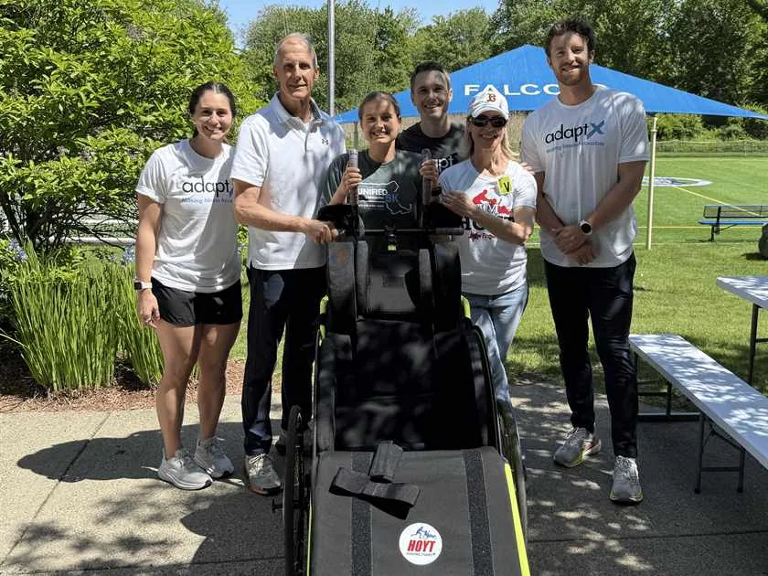 The AdaptX team and volunteers standing with a Hoyt running chair at the Cotting School demo day