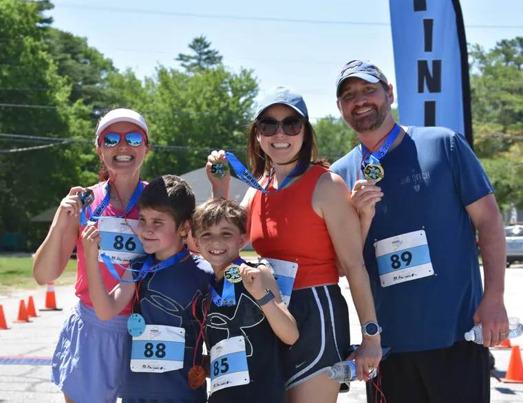 A family of finishers holding up their medals together
