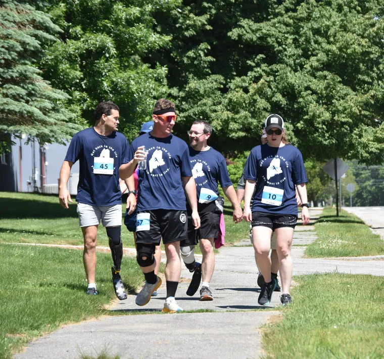 Four participants in AdaptX shirts walking the course together