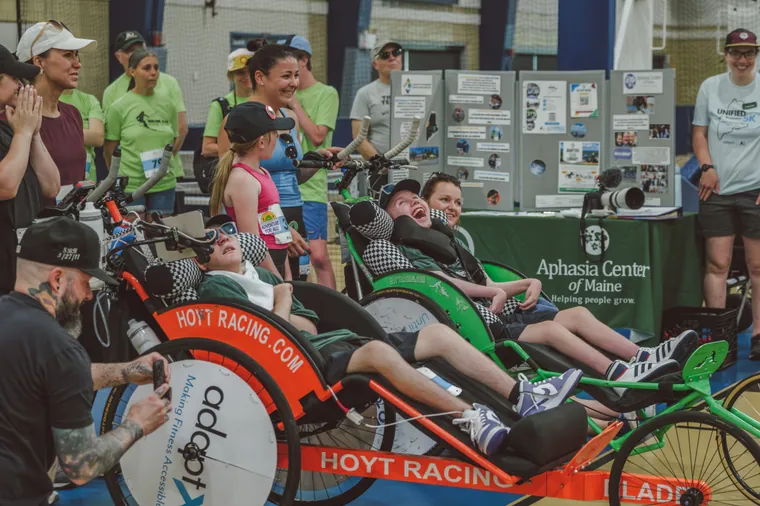 Athletes in Hoyt racing chairs lined up beside the stands