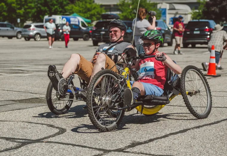 Two handcyclists racing side by side on the road