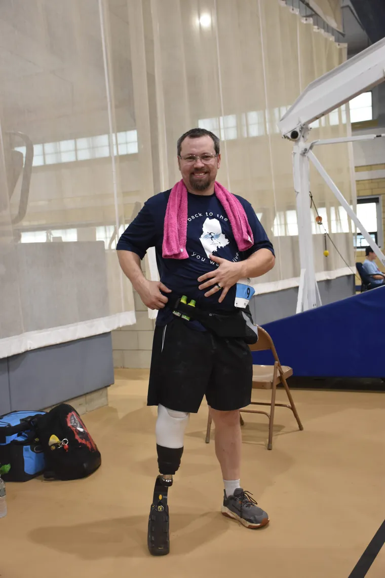 Sean Cooney standing on his new running blade indoors