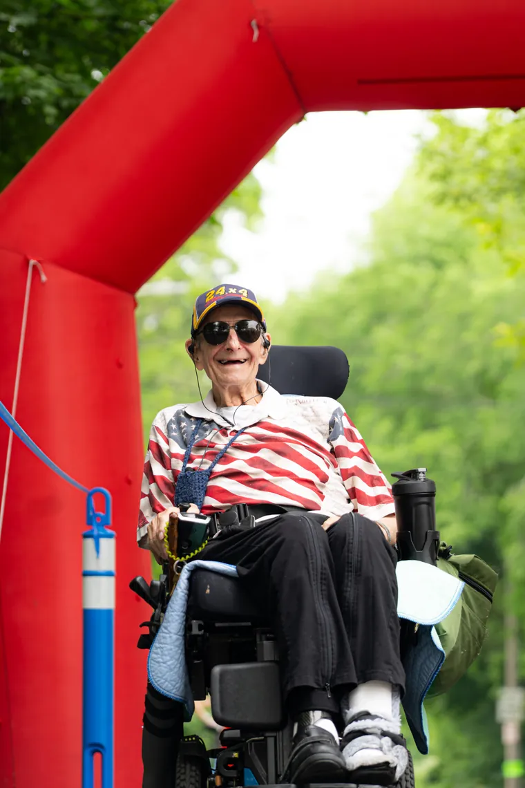 A participant in a power wheelchair under the red start arch