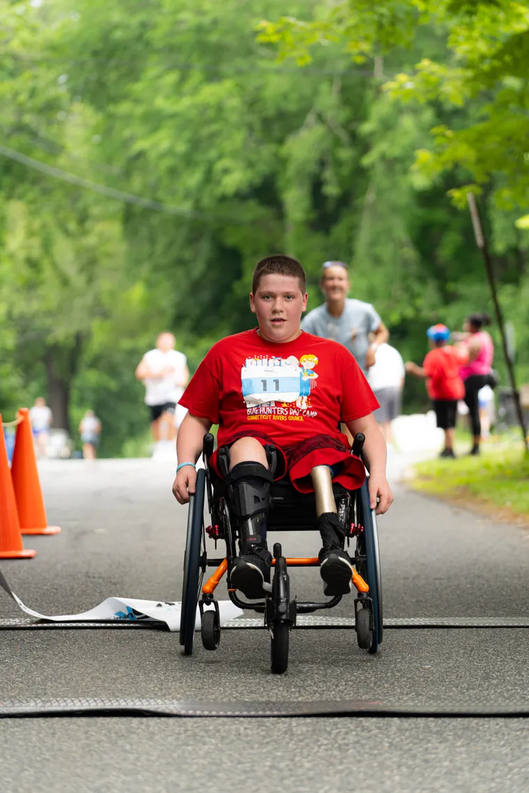 A young racer in a racing chair coming down the course