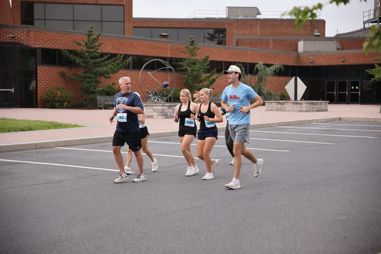 Four runners together on the road at Messiah University