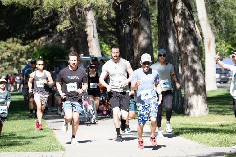 A pack of runners on the park path under the trees