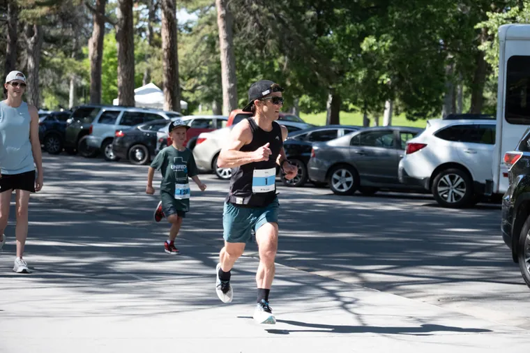 A runner and a child running the last stretch together