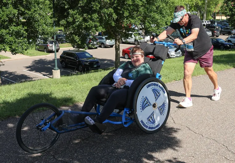 A volunteer giving a racing chair a push at the start